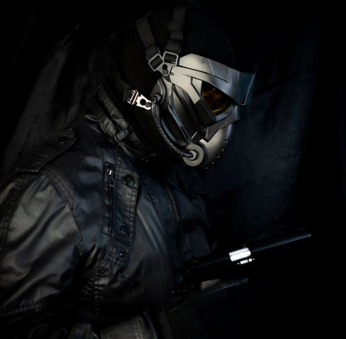 A Person in a Mask and Black Outfit Holding a Gun