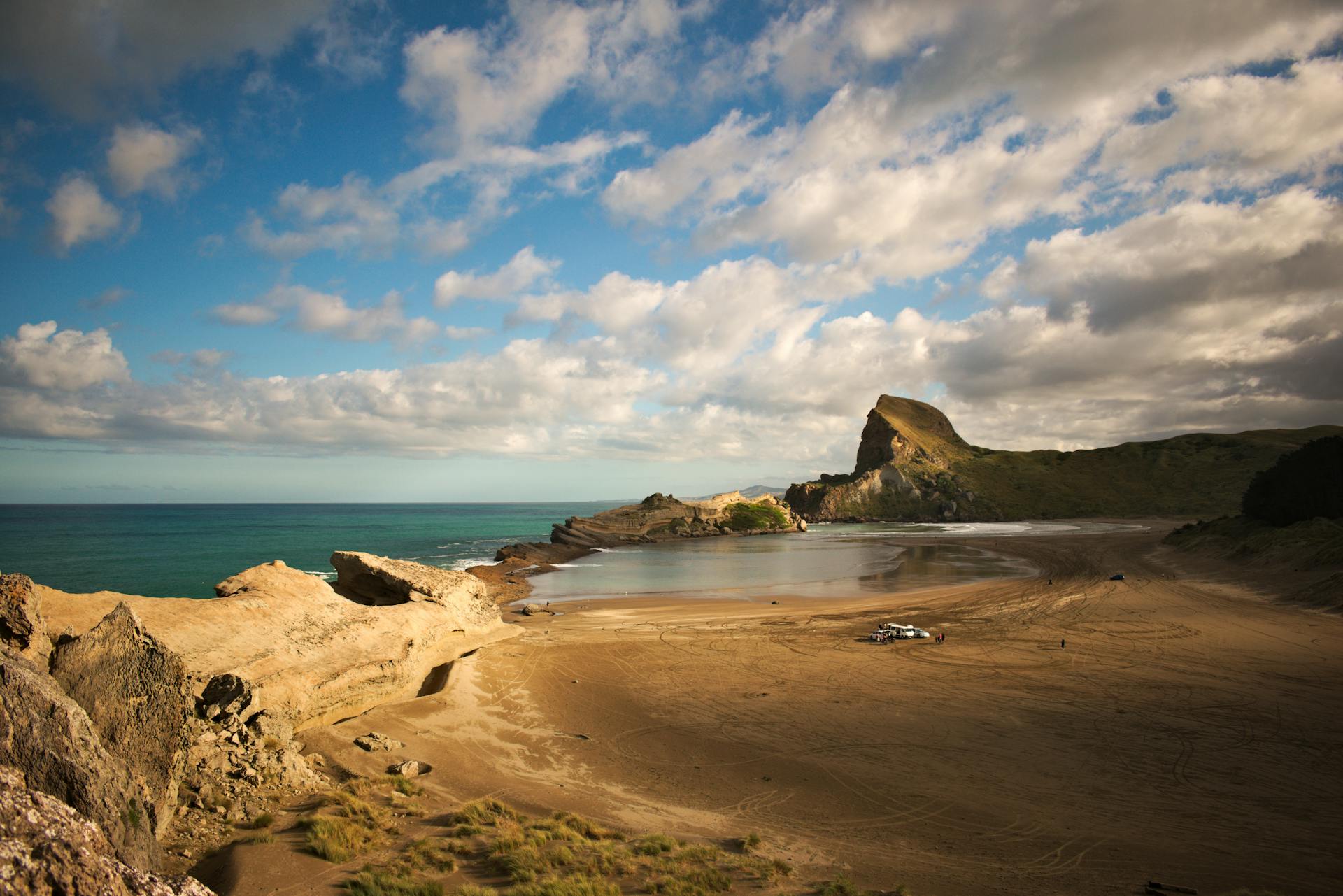 Beautiful coastal landscape of Castlepoint Beach, New Zealand with stunning rock formations under a vibrant sky.