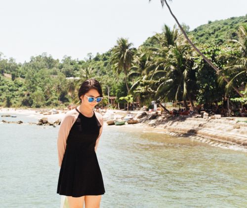 Free A young woman with sunglasses enjoys a sunny day by the tropical seaside. Stock Photo