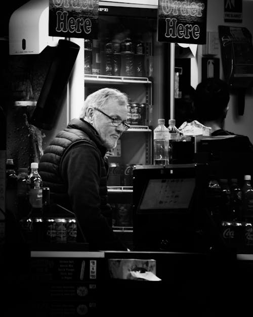 Grayscale Photo of a Man in a Cafe