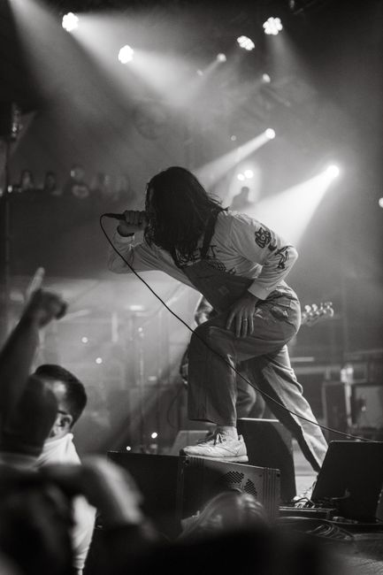 Black and white photo capturing a singer in an intense live performance on stage.