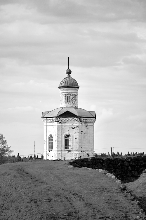 Free Black-and-white image of a historic chapel on a hill under a cloudy sky. Stock Photo