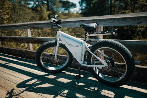 Free White and Black Mountain Bike Parked on Gray Wooden Bridge Stock Photo