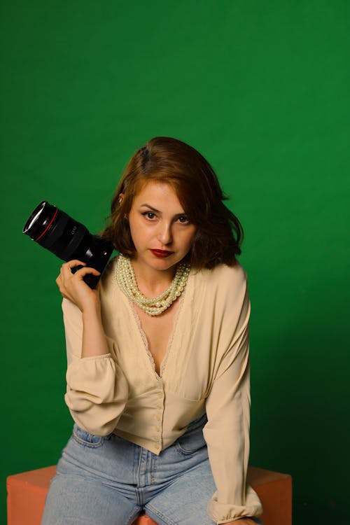 Woman in Beige Long Sleeves Holding Black Camera