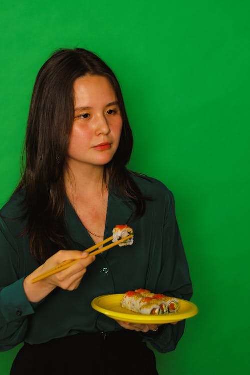 Woman in Black Long Sleeve Shirt Eating Sushi