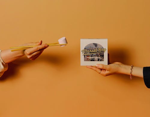 Chopsticks with Marshmallow held by a Person 