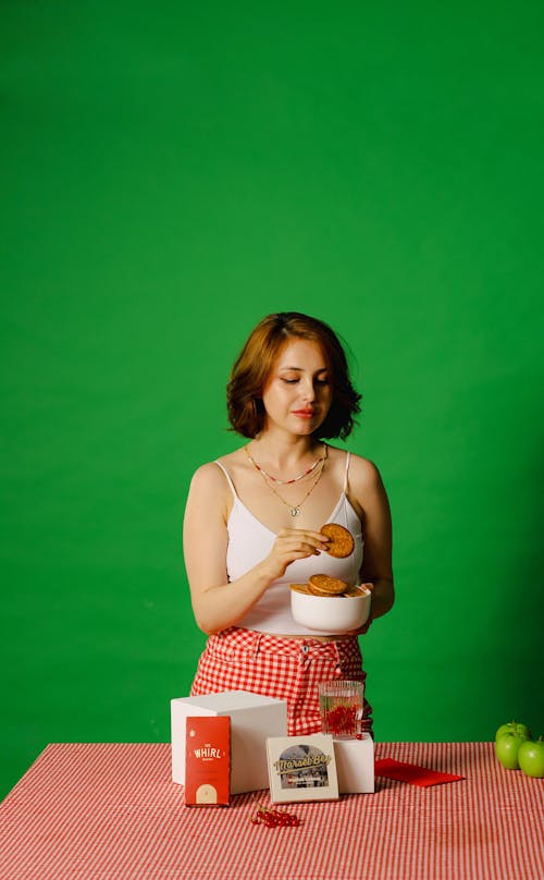Studio Shot of Woman with Cookies against Green Background