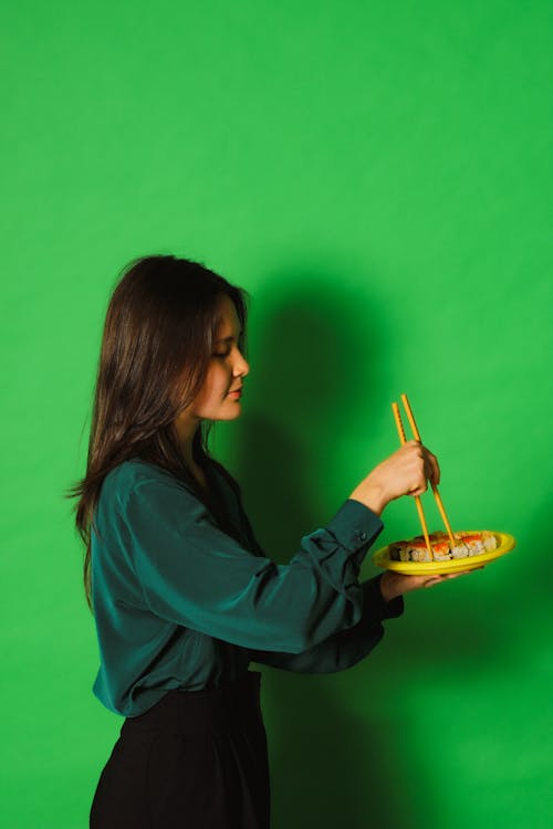 A Woman Holding a Plate and Chopsticks