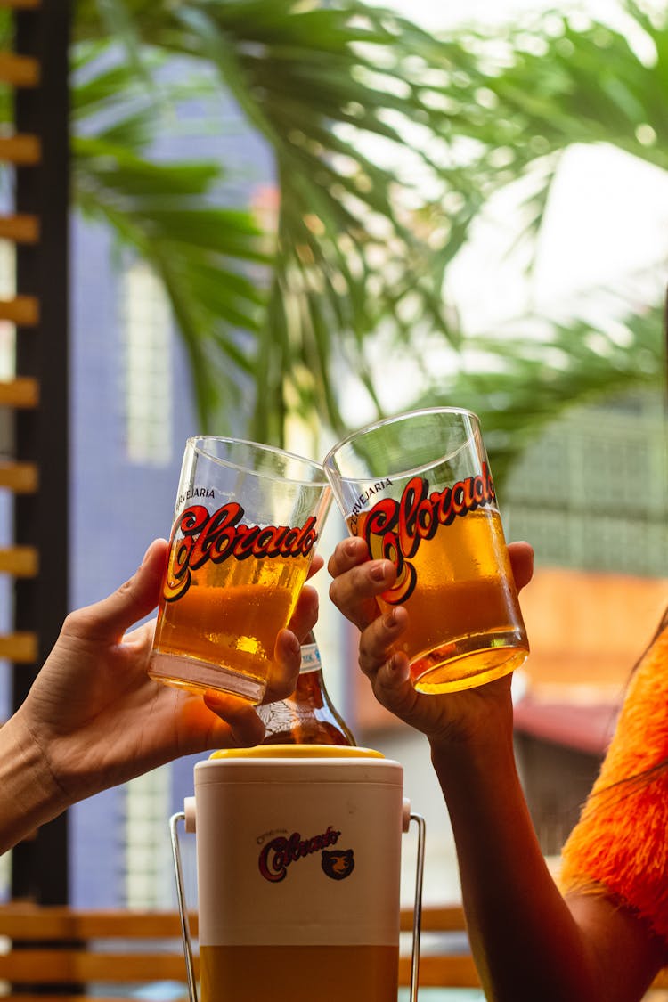 Two People Cheers A Beer