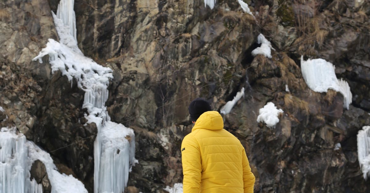 Person in Yellow Bubble Jacket standing near a Rock Formation · Free ...