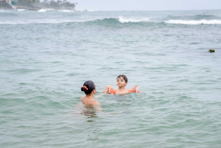 Mother And Son Swimming On The Sea 