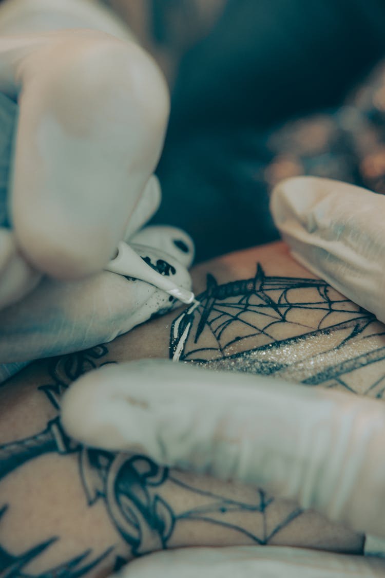 Artist Filling In Tattoo With White Ink