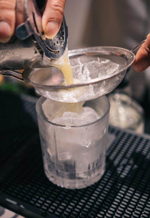 Free Pouring of Liquid in a Glass full of Ice  Stock Photo