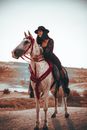 Woman in a Black Hat on a White Horse with Red Harness