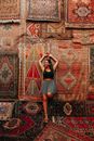Woman in Black Tank Top and Black Shorts Sitting on Red and Beige Floral Rug