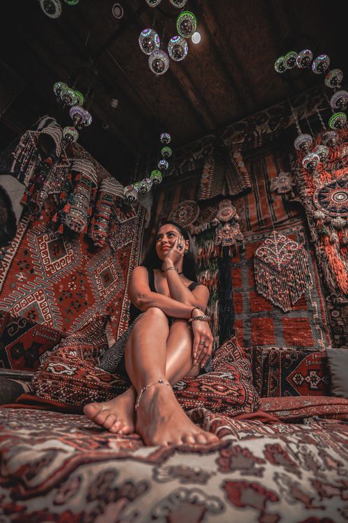 Free Stylish woman posing in a beautifully decorated Turkish room with ethnic textiles. Stock Photo
