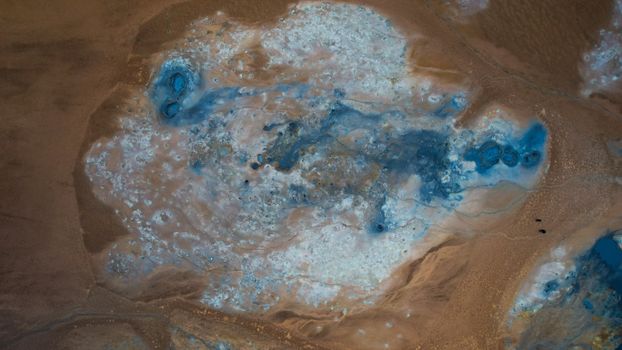 Stunning aerial view of Reykjahlíð's geothermal landscape with vivid blue mineral deposits.