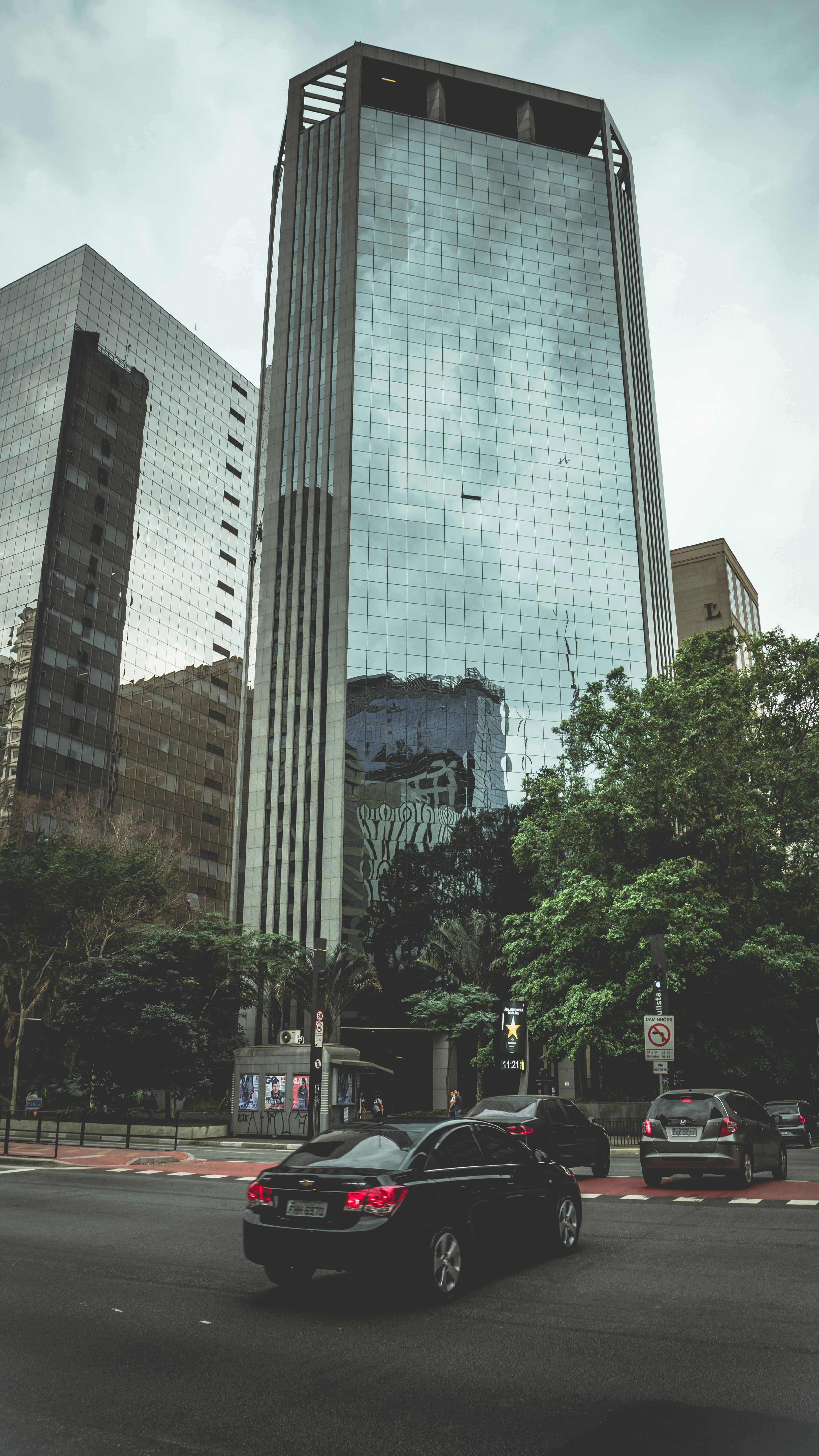 繁华的城市环境中，高大的玻璃摩天大楼倒映着身影