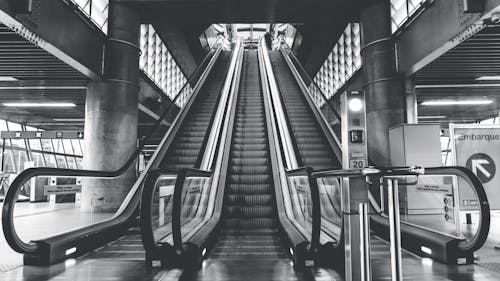 Grayscale Photography of Airport Escalators