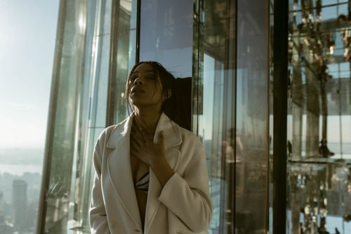 Free Stylish woman posing in a glass skyscraper with cityscape view. Stock Photo