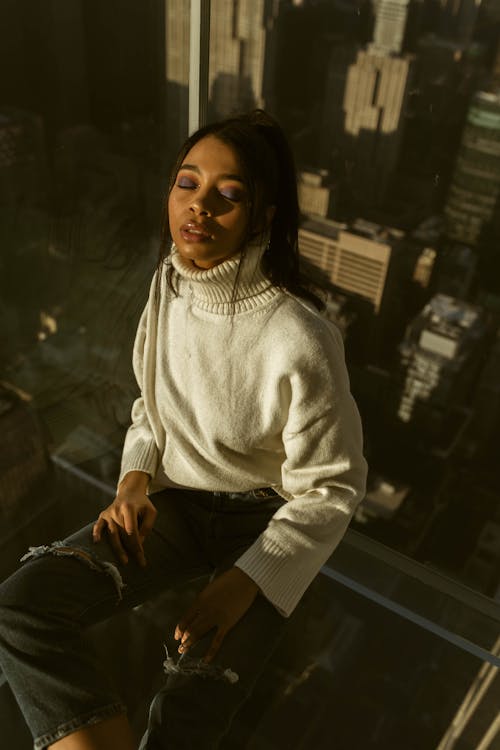 Woman Wearing a White Turtleneck Sweater and Ripped Jeans 