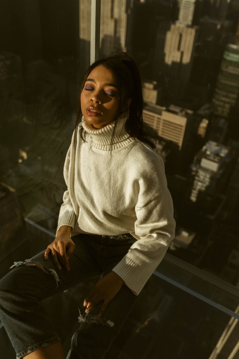 Woman wearing white turtleneck sweater and ripped jeans