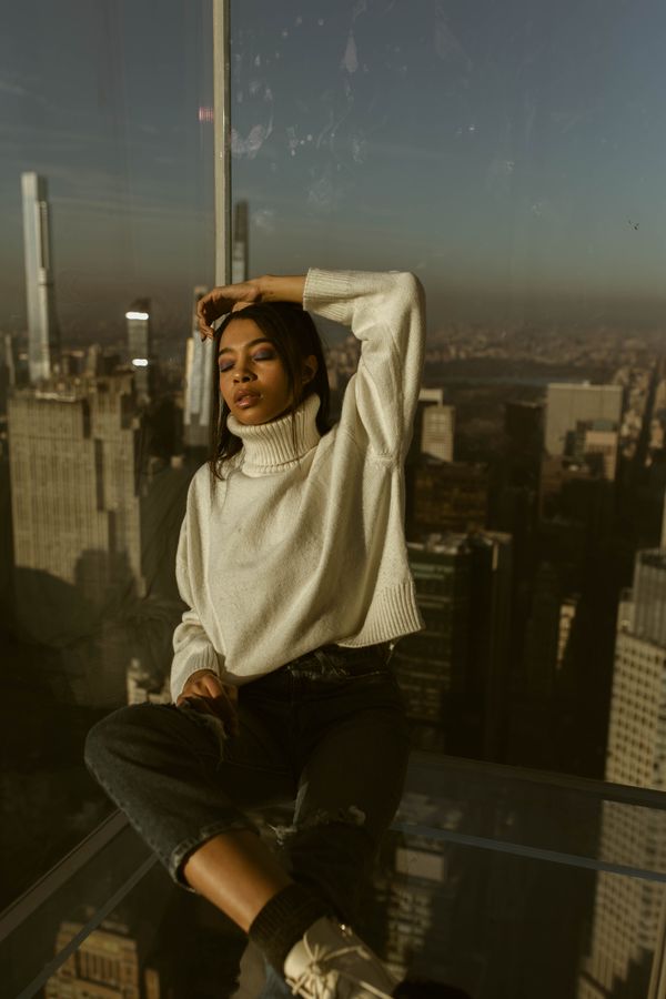 Woman wearing a coffee ribbed turtleneck with distressed jeans