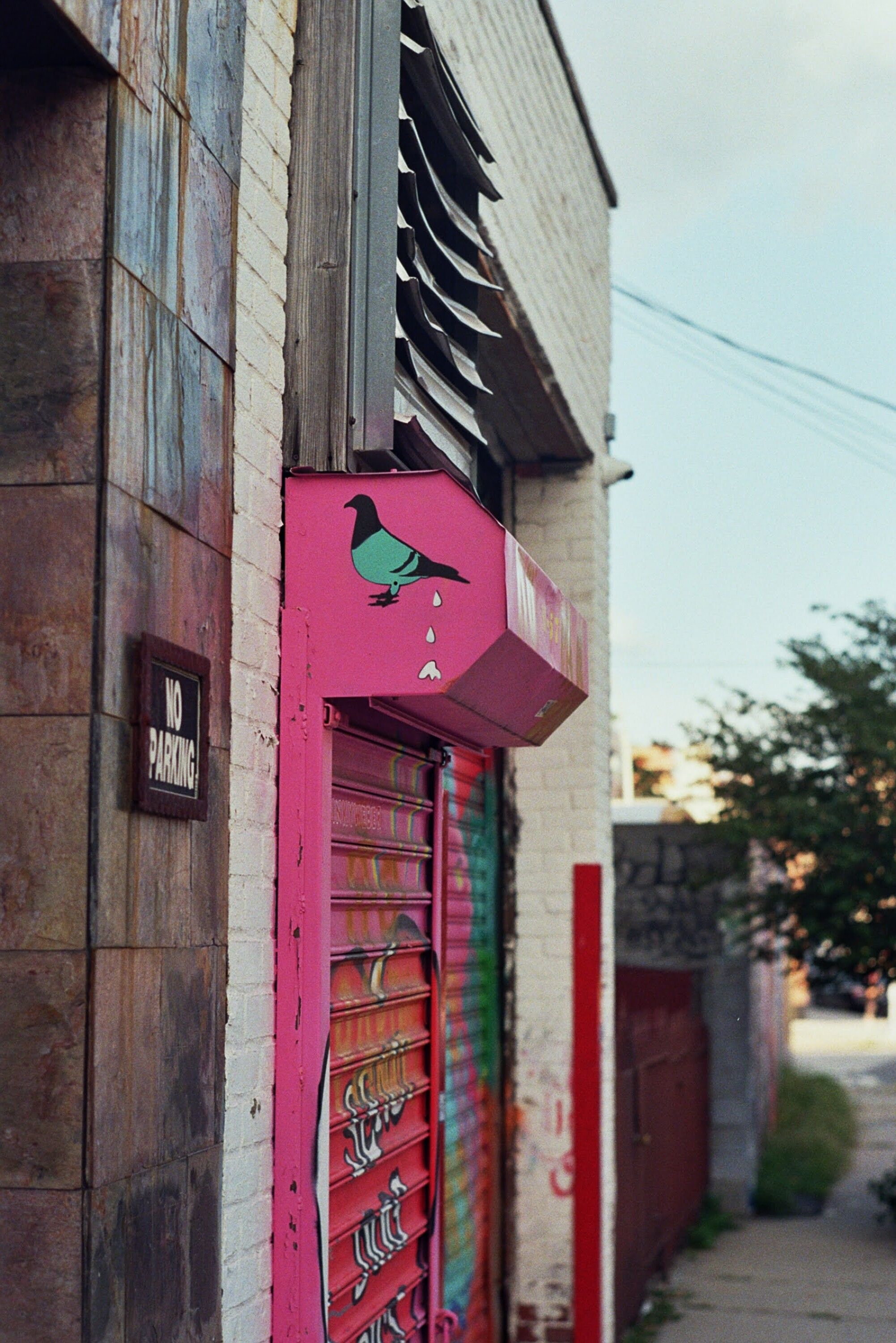 Explore a lively urban scene featuring a colorful pink roll-up door and street art.