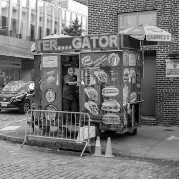A street vendor at a New York City halal food truck in black and white.