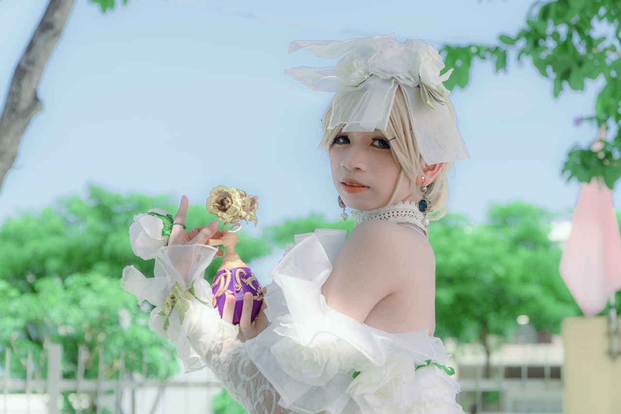 cosplayer in elegant white costume posing with flower outdoors