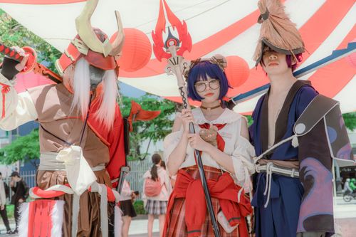 Free Three cosplayers dressed as fantasy characters pose together under vibrant canopy outdoors. Stock Photo