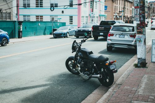 Free A motorcycle parked on a busy urban street lined with various other vehicles and buildings. Stock Photo