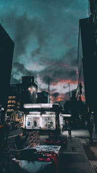 暮光下的城市景观充满戏剧性，明亮的城市灯光倒映在暴风雨的天空中