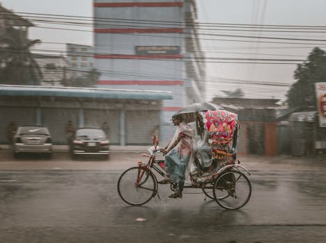 A vibrant rickshaw navigates a rainy street in Bangladesh, capturing the essence of daily life.