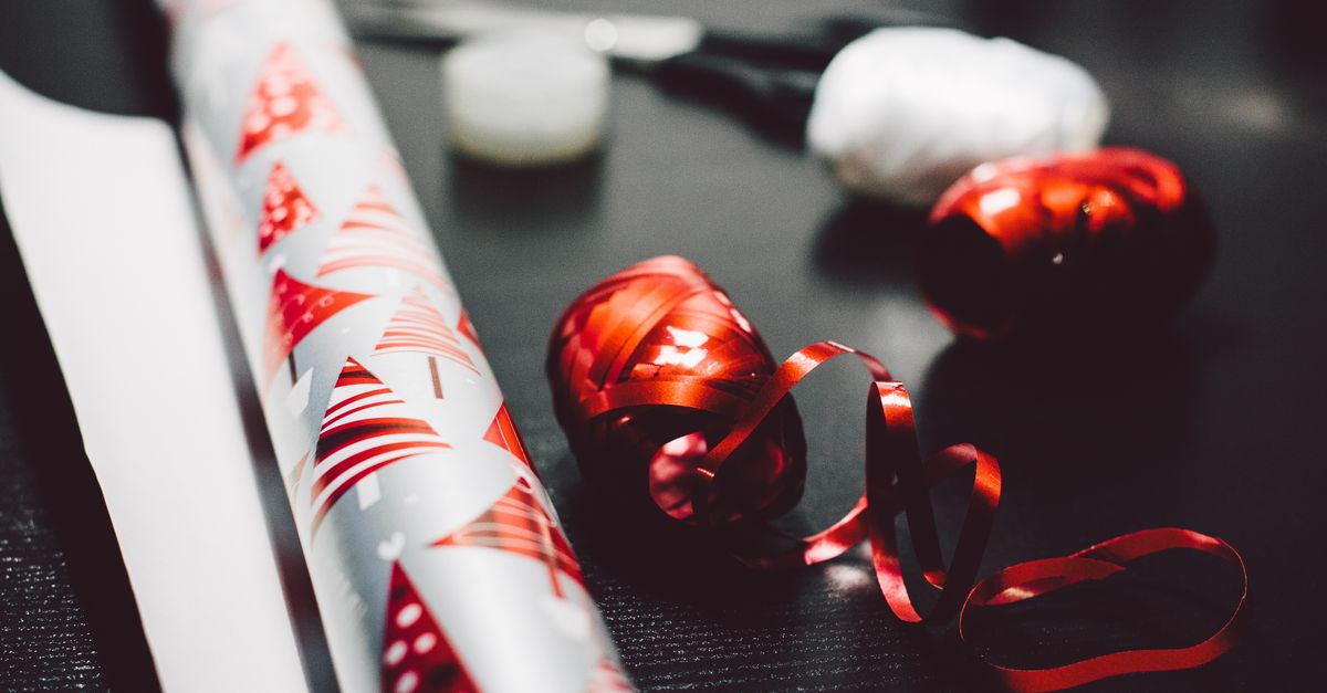 Papel de presente colorido e fita vermelha criam a atmosfera perfeita para a preparação de presentes de Natal.