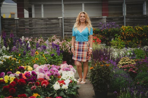 Woman Standing on Paved Walkway in a Garden