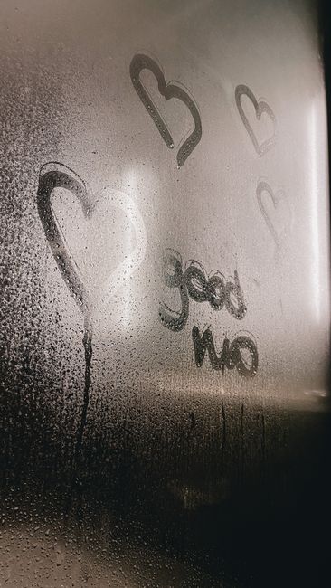 Steamy glass with heart doodles and 'good mo' text, ideal for romantic concepts.