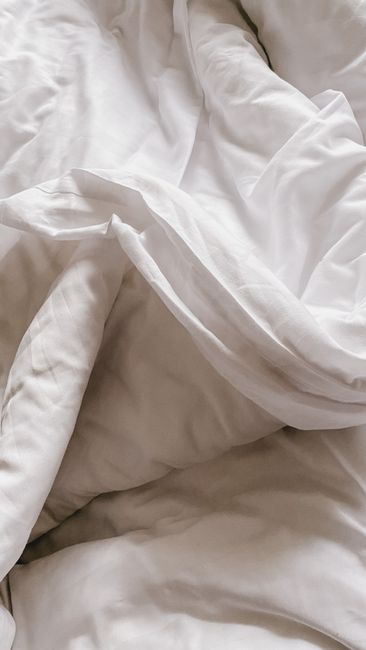 Detailed view of white linen sheets, emphasizing softness and casual elegance.