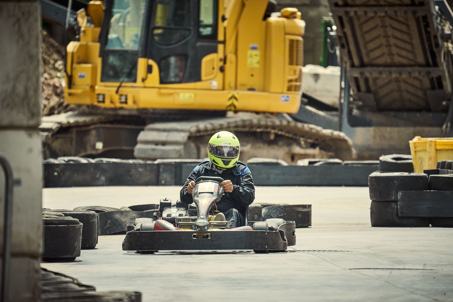 High-speed go-kart racing on an outdoor track with construction vehicles in the background. Thrilling and fun.