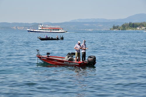 Free Men standing on a Speedboat while Fishing on a River  Stock Photo