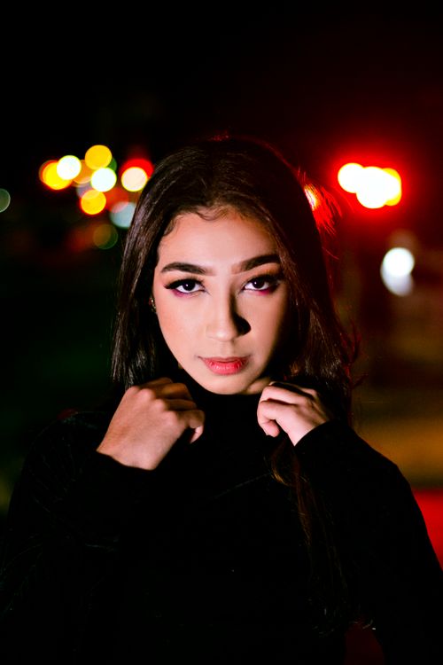 Free Elegant nighttime portrait of a woman with vibrant bokeh lights, showcasing makeup and long hair. Stock Photo