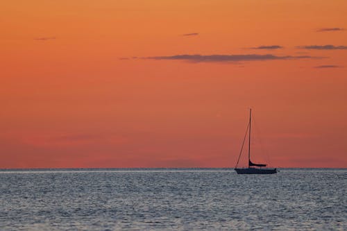 Silhouette of Sailboat on Body of Water