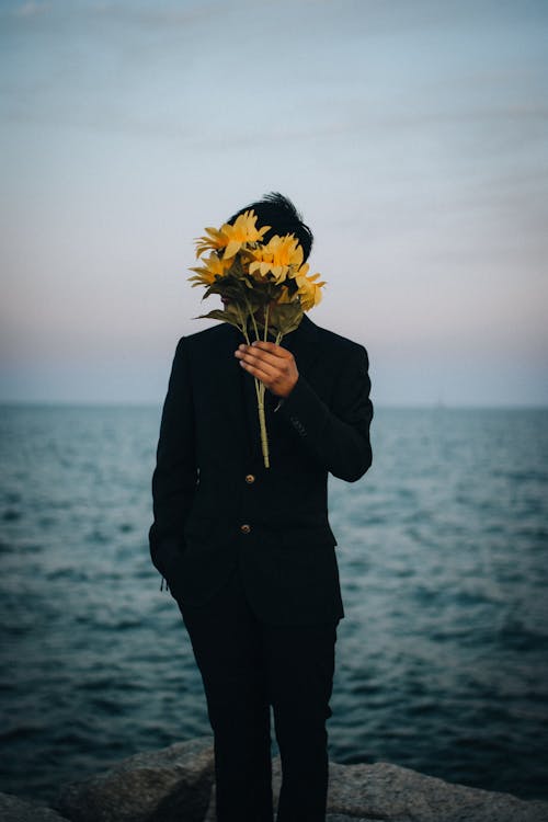 Kostnadsfri bild av ansikte täckt, gula blommor, person