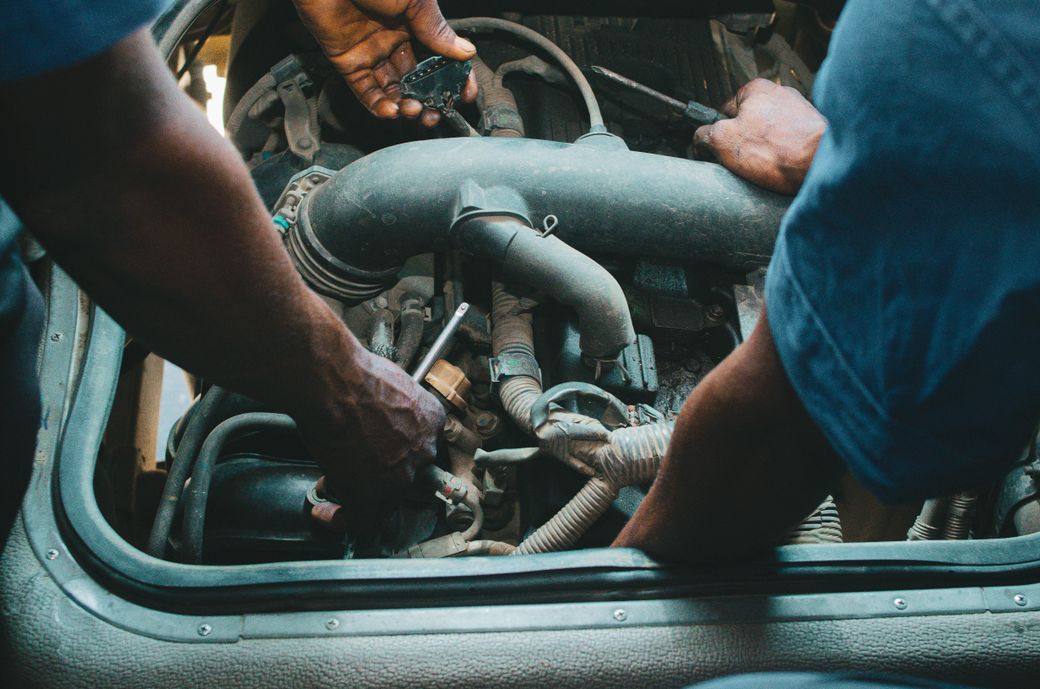 Auto mechanic working on an engine, close-up of hands and tools