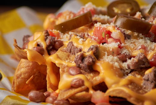 Delicious close-up of nachos topped with cheese, jalapeños, and beans, perfect for food lovers.