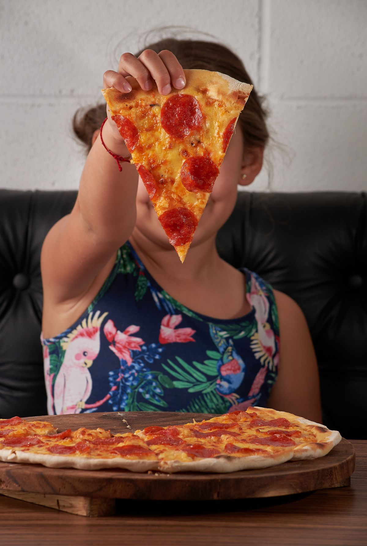 Hand holding slice of pizza