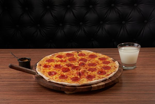 Freshly baked pepperoni pizza on a wooden serving board — photo by Alejandro Aznar on Pexels