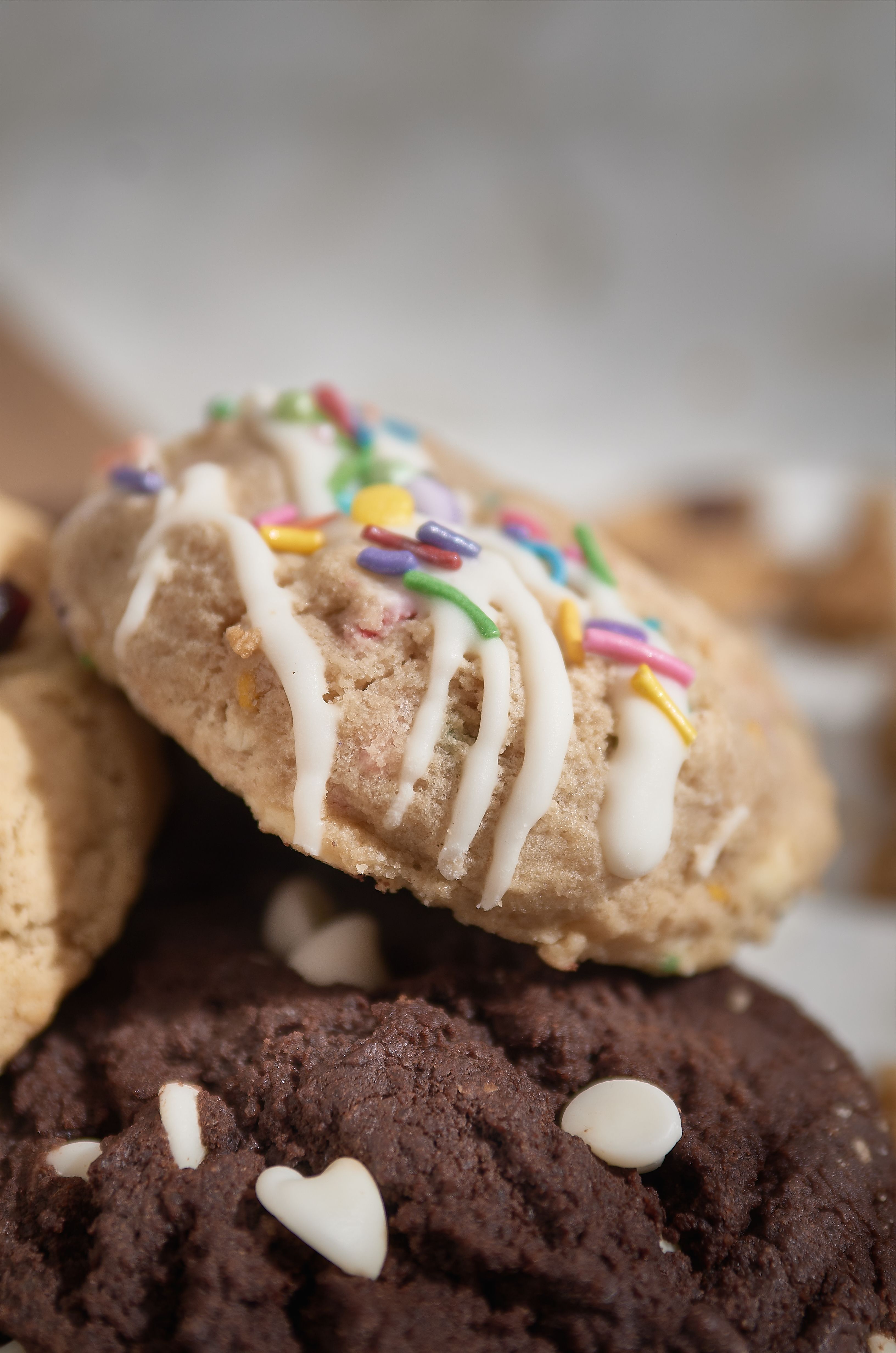 A stack of soft chocolate chip cake mix cookies with crackled tops, cooling on a wire rack.