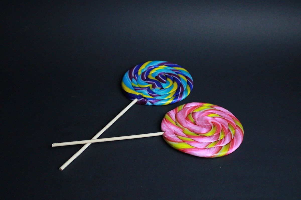 Şeker ve lolipop figürleri ahşap masa üzerinde renkli düzen