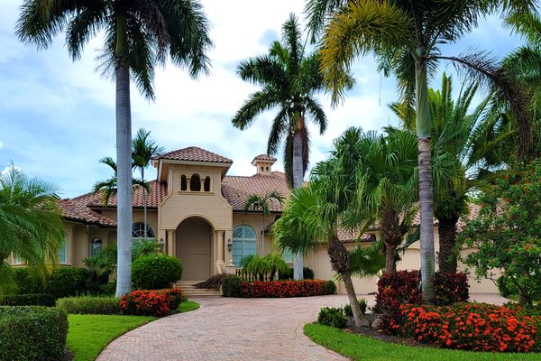 Elegant mansion with lush palm trees and large windows